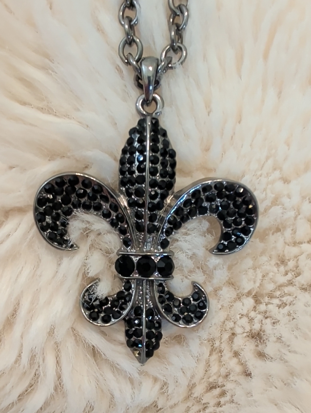 36" fleur-de-lis pendant necklace features a pave-set design.